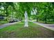 A statue graces a tree-lined residential street, with well-maintained homes and parked cars visible in the background at 774 Woodruff Pl E Dr, Indianapolis, IN 46201