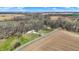 An aerial view of the property showing the surrounding fields, trees, and a blue-colored house at 7916 W 275 N, Boggstown, IN 46110