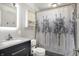 Updated bathroom featuring a modern vanity, decorative shower curtain, and lighted mirror at 7916 W 275 N, Boggstown, IN 46110