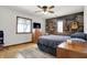 Relaxing bedroom features a wood accent wall, natural light, and ceiling fan, creating a cozy retreat at 7916 W 275 N, Boggstown, IN 46110