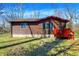 Charming single-story home with rustic wood siding and a red deck, nestled in a natural setting at 7916 W 275 N, Boggstown, IN 46110