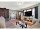 Cozy living room featuring hardwood floors, a rustic fireplace, and ample seating for entertaining guests at 7916 W 275 N, Boggstown, IN 46110