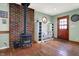 Charming living room showcasing a wood-burning stove, brick surround, and ample natural light from the front door at 7916 W 275 N, Boggstown, IN 46110