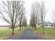Long driveway lined with trees leads to a charming two-story farmhouse with a wrap around porch at 7984 S Deer Lake Dr, Nineveh, IN 46164