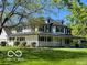 Stunning two-story home featuring a welcoming wrap-around porch, a well-manicured lawn, and mature shade trees at 7984 S Deer Lake Dr, Nineveh, IN 46164