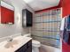 Cozy bathroom featuring a red accent wall, vanity, mirror, and a shower with a striped curtain at 946 Peppermill Run, Greenwood, IN 46143