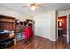 Bedroom with wood floors, closet, ceiling fan, and a view to an adjacent red bathroom at 946 Peppermill Run, Greenwood, IN 46143