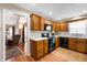 Functional kitchen with wood cabinets, black appliances, and a view to living room at 946 Peppermill Run, Greenwood, IN 46143