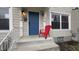 Close up of a charming front porch featuring a bright blue door, a red chair, and neutral-colored siding at 952 E 34Th St, Indianapolis, IN 46205