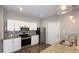 Well-lit kitchen featuring white cabinets, stainless steel appliances, granite countertops, and wood-look flooring at 952 E 34Th St, Indianapolis, IN 46205