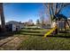 Spacious backyard with mature trees, playground, trampoline, and swing set at 9619 E Southport Rd, Indianapolis, IN 46259