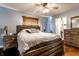 Comfortable bedroom with hardwood floors, a ceiling fan, and a large window with wood blinds at 9619 E Southport Rd, Indianapolis, IN 46259