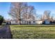 Ranch-style home with stone accents, well-maintained lawn, mature trees, and classic charm on a sunny day at 9619 E Southport Rd, Indianapolis, IN 46259