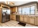 Bright kitchen featuring stainless steel appliances, light wood cabinetry, and a bay window above the sink at 9619 E Southport Rd, Indianapolis, IN 46259