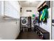 Functional laundry room featuring modern washer and dryer, storage shelves and convenient shoe storage at 9619 E Southport Rd, Indianapolis, IN 46259