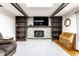 Cozy living room with a stone fireplace, wood beams, built-in shelving, and hardwood floors at 9619 E Southport Rd, Indianapolis, IN 46259