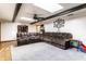 Spacious living room with exposed beams, a ceiling fan, a large sofa, and hardwood floors at 9619 E Southport Rd, Indianapolis, IN 46259