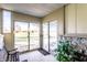 Bright sunroom with stone accents, a bench, a plant, and sliding glass doors leading to the yard at 9619 E Southport Rd, Indianapolis, IN 46259