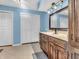 Bathroom with blue walls, tile flooring, wood cabinets, and a framed mirror at 108 Parkridge Dr, Danville, IN 46122