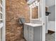 Bathroom featuring modern vanity, towel rack, and brick accent wall at 108 Parkridge Dr, Danville, IN 46122