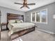 Cozy bedroom with a large window, ceiling fan, a wooden headboard and carpeted floor at 108 Parkridge Dr, Danville, IN 46122