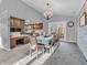 Open dining room area with wood table set beneath a chandelier, next to kitchen and leading to back patio at 108 Parkridge Dr, Danville, IN 46122