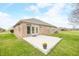 A brick home with a concrete patio and flower planters in a backyard with green grass and blue skies at 1120 Constitution Dr, Edinburgh, IN 46124