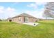 A brick home with a concrete patio and flower planters in a backyard with green grass and blue skies at 1120 Constitution Dr, Edinburgh, IN 46124