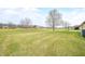 A backyard with green grass, a walking path, trees, and the side of a brick home with an air conditioning unit at 1120 Constitution Dr, Edinburgh, IN 46124