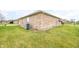 The side of a brick home with green grass, an air conditioning unit, a satellite dish and a walking path at 1120 Constitution Dr, Edinburgh, IN 46124