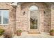 Close-up of a charming brick home's front door with 'Welcome' mat and potted flowers at 1120 Constitution Dr, Edinburgh, IN 46124