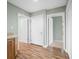 Hallway featuring wood look flooring and three white doors at 1120 Constitution Dr, Edinburgh, IN 46124