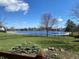 Scenic lake view from the backyard featuring a well-maintained lawn and wrought iron fence at 11967 Windpointe Pass, Carmel, IN 46033