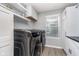 Bright laundry room with modern washer and dryer, white cabinets, and wood-look floors at 1283 Cliff View Dr, Westfield, IN 46074