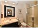 Bathroom features a glass enclosed shower, dark vanity with light countertop, and a decorative framed mirror at 12917 Brighton Ln, Carmel, IN 46032