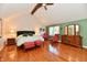 Vaulted ceiling bedroom with hardwood floors, a ceiling fan, and a sitting area with red accents at 12917 Brighton Ln, Carmel, IN 46032