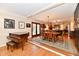 Open-concept living room and dining area featuring hardwood floors, natural light, and a piano at 12917 Brighton Ln, Carmel, IN 46032