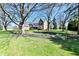 Charming brick home featuring a manicured front yard with mature trees and flower beds at 12917 Brighton Ln, Carmel, IN 46032