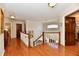 Bright hallway features hardwood floors, and staircase with white railing, and an open doorway at 12917 Brighton Ln, Carmel, IN 46032