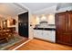 Wet bar in a kitchen featuring built-in cabinets, a dark countertop, and under-cabinet lighting at 12917 Brighton Ln, Carmel, IN 46032