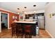 Basement wet bar area with dark cabinetry, light countertops, stainless steel refrigerator, and three bar stools at 12917 Brighton Ln, Carmel, IN 46032