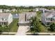 Aerial view of a traditionally styled home with a pond, manicured lawn, mature trees, and multi-car garage at 12959 Balfour Rd, Fishers, IN 46037