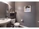 Charming powder room with gray walls, pedestal sink, and tasteful decorations over the toilet at 12959 Balfour Rd, Fishers, IN 46037