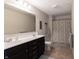Well-lit bathroom with double sink vanity, large mirror, tile floors, and shower with curtain at 12959 Balfour Rd, Fishers, IN 46037