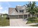 A charming two-story home features a well-manicured lawn, pond and an attached two-car garage at 12959 Balfour Rd, Fishers, IN 46037