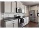 Kitchen features stainless steel appliances, granite counters, white cabinetry, and subway tile backsplash at 12959 Balfour Rd, Fishers, IN 46037