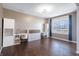 Bright living room offers hard wood floors, large window with blue curtains, and built-in shelves at 12959 Balfour Rd, Fishers, IN 46037