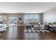 Bright living room with hardwood floors, large windows, and a comfortable gray sectional sofa at 12959 Balfour Rd, Fishers, IN 46037