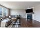 Relaxing living room showcases hardwood floors, natural light, a comfortable sofa, and fireplace at 12959 Balfour Rd, Fishers, IN 46037