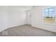 A bright bedroom with neutral colored carpet features two windows at 13752 N George Ct, Camby, IN 46113